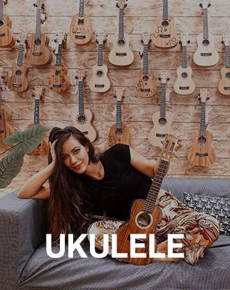 Person smiling while holding a ukulele in a relaxed setting